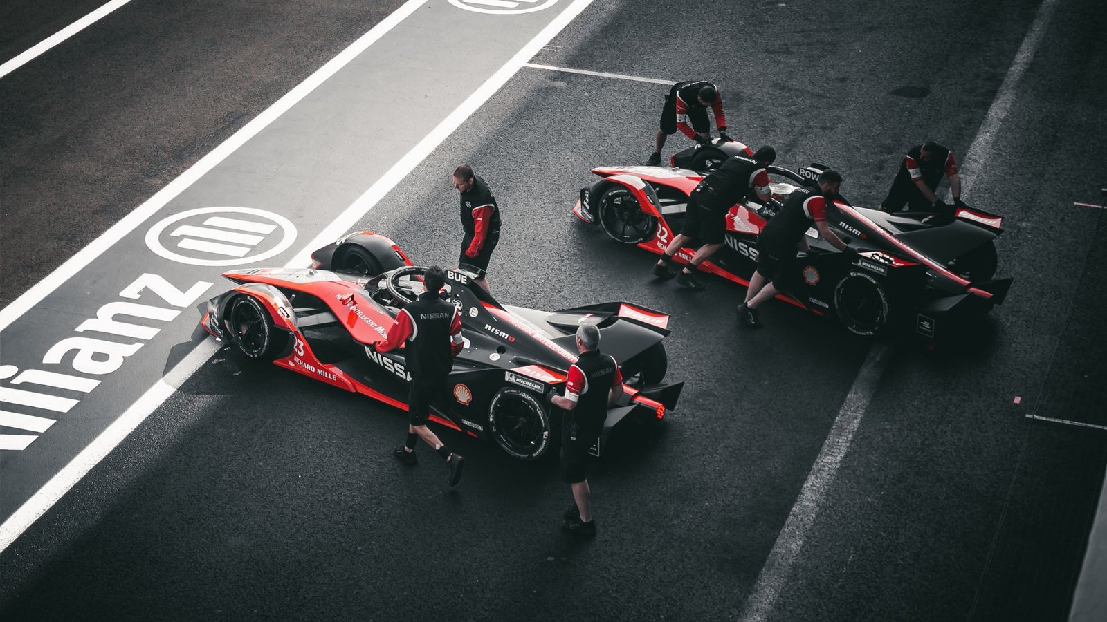 Pit crew working on race cars at a motorsport event in Mexico City.